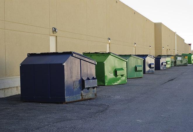 a series of colorful, utilitarian dumpsters deployed in a construction site in Newbury